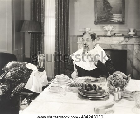 Man and his pet turkey sitting down to an untraditonal Thanksgiving dinner