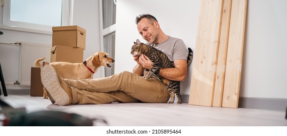 A Man With His Pets Moving Into A New Empty Apartment