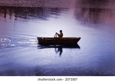 A man in his rowing boat, calm summer's morning