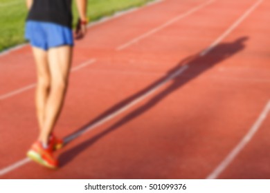 Man and his shadow on running track at street stadium