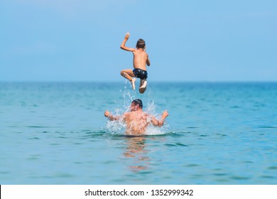 A Man With His Son Swimming In The Sea. Rest In Crimea. Black Sea. A Man Throws A Boy Over The Water.