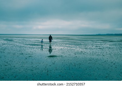 A Man With His Son Walking Along The Sandy Beach In Denmark, Romo