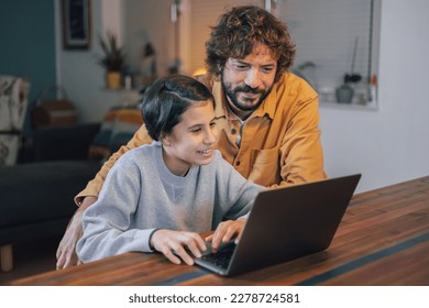 Man with his teenage daughter using laptop together at home - Powered by Shutterstock