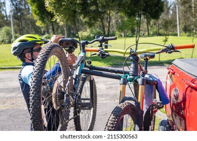 Man in his thirties and forties with a bike helmet loading his bike into his truck - Powered by Shutterstock