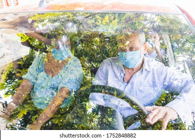 A Man With His Wife And Daughter Wearing A Protective Mask Driving. Mature Couple Driving In The Car With A Mask.