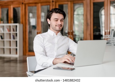 man at his workplace with phone and laptop in the office