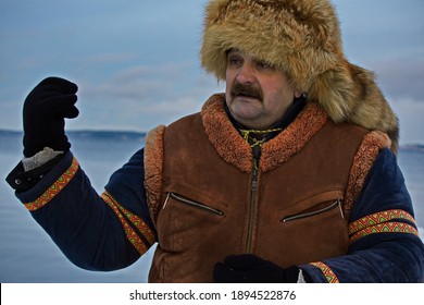 A Man In A Historical Sami Costume On The Embankment Of Lake Onega.