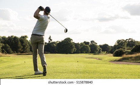 Man hitting driver on a golf course in the sun
