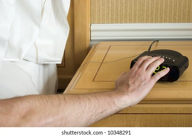 Man Hitting Snooze Button On Alarm Clock