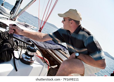 Man Hoisting Sail On Yacht