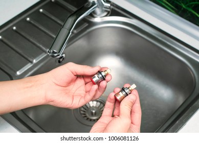 Man Hold Cartridge Or Mixer Of The Faucet, Plumber Repairing The Faucet Of A Sink In Kitchen, Repair And Fixing Leaky Old Faucet, Concept Of Repair And Technical Assistance