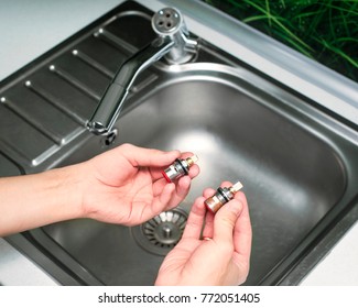 Man Hold Cartridge Or Mixer Of The Faucet, Plumber Repairing The Faucet Of A Sink In Kitchen, Repair And Fixing Leaky Old Faucet, Concept Of Repair And Technical Assistance