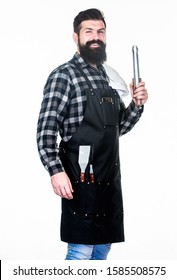 Man hold cooking utensils barbecue. Tools for roasting meat outdoors. Picnic and barbecue. Cooking meat in park. Barbecue master. Bearded hipster wear apron for barbecue. Roasting and grilling food.