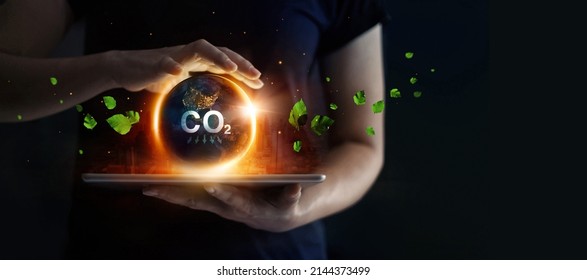 Man hold earth energy at night on tablet depicting the issue and reduce CO2 emissions carbon. Global warming and climate change. Energy saving, Sustainable development. Earth day.  - Shutterstock ID 2144373499
