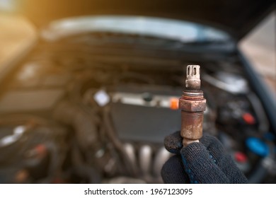 Man hold in hand faulty old oxygen sensor of exhaust system, car stalled, fault in emission system, maintenance of motor vehicle. Check and replace faulty lambda sensor. Mechanic hold oxygen sensor - Shutterstock ID 1967123095