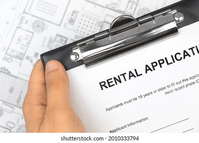 Man Hold Rental Application Form. Office Business Background With Property House Form