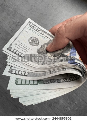  Man hold us money, counting one hundred dollar bills. Saving concept