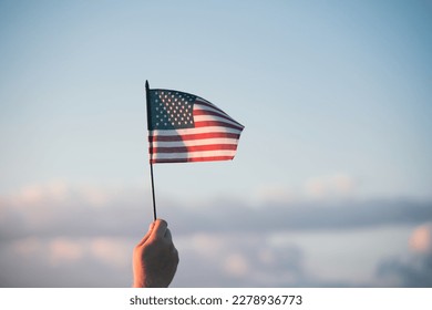 Man holding american USA flag in the sunset. Independence Day or traveling in America concept. - Powered by Shutterstock