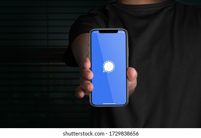  Man holding Apple iPhone 11 displaying Signal app logo. Social media network. Signal Messenger, LLC. Privacy focused app. Advanced privacy-preserving technology.
