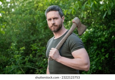 man holding axe outdoor. photo of man with axe. man with axe. man with axe wearing shirt