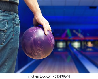 Man Holding Ball Against Bowling Alley