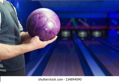 Man Holding Ball Against Bowling Alley