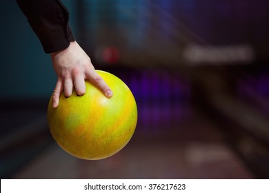 Man Holding Ball Against Bowling Alley.