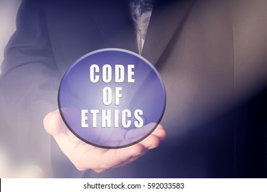 Man Holding Ball With CODE OF ETHICS Text. Business Concept