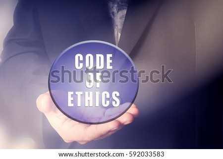 Man holding ball with CODE OF ETHICS text. Business concept