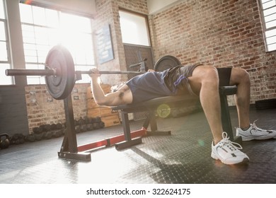 Man holding barbell lying on bench at the gym