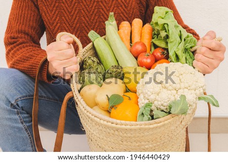 Man holding a basket full of organic veggies. Natural product concept.