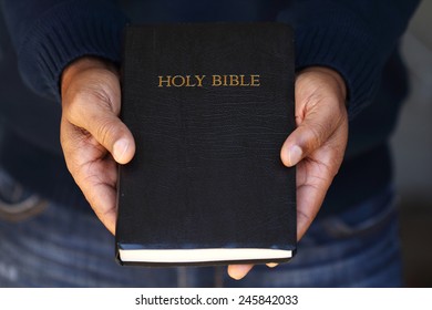 Man Holding A Bible In His Hand.