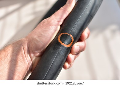 Man holding bike tyre - repairing flat bike tyre with bicycle puncture repair kit - Powered by Shutterstock