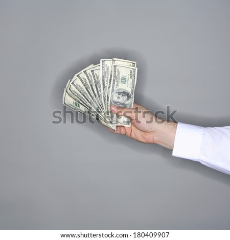 man holding bills on grey 