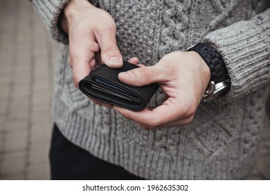 The Man Is Holding A Black Leather Wallet. Close-up, Horizontal Orientation, No Face.