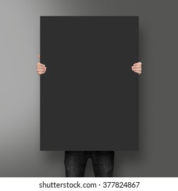 Man holding black poster mockup on the blank background