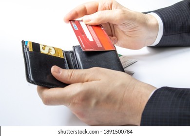 Man Holding A Black Wallet In His Hand. Credit Card Usage. Conscious Consumers. Consumer Shopping Habits. Photographed Close-up In Front Of A White Background.Credit Cards In Black Wallet. 