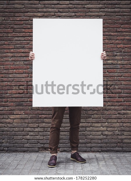 Man holding blank\
poster
