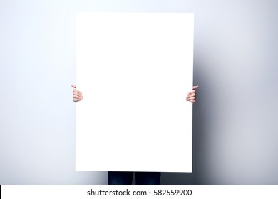 Man Holding Blank Poster On Grey Background