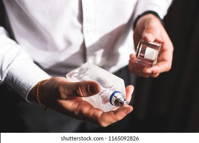 Man Holding Bottle Of Perfume And Smells Fragrance