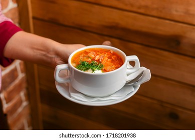 Man Holding A Bowl Of Soup. Waiter Serving Fresh Hot Soup In A Diner Or Restaurant. Healthy Delicious Dinner. Waiter At Work. Restaurant Service.