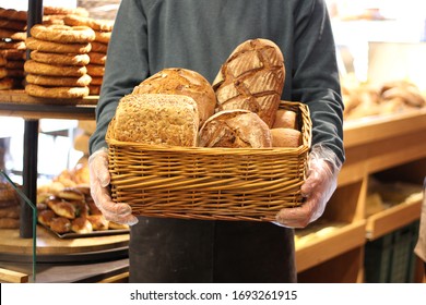 Man Holding Breads In A Bakery