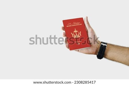 Man holding Brunei Passport in hand on white background with copy space - Bruneian
