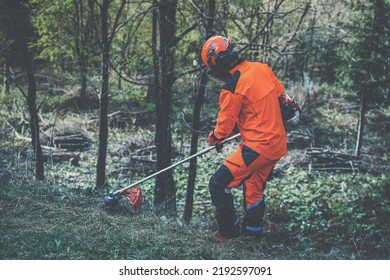 Man holding a brushcutter cut grass and brush. Lumberjack at work wears orange personal protective equipment. Gardener working outdoor in the forest. Security, occupation, forestry, worker, concept - Powered by Shutterstock