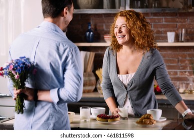 Man Holding Bunch Of Flowers Behind Back