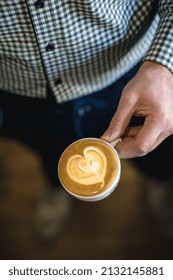 Man Holding Caffee Latte With Latte Art Heart Overhead Indoor