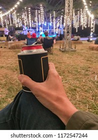 A Man Holding A Can Of Cold Beer In A Insulation Sleeve By To Party In The Yard