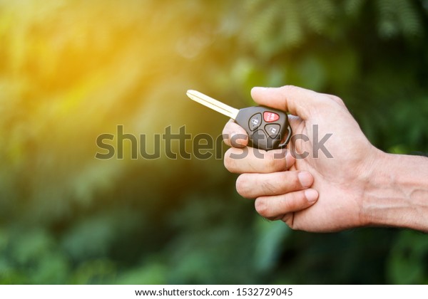 A man holding car key on nature background,\
journey of life concept