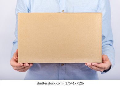 Man Holding Cardboard Box. Front View. Parcel Delivery Home. Express Delivery