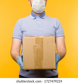 Man holding cardboard boxes in medical rubber gloves and mask. Coronavirus pandemic quarantine delivery concept - Shutterstock ID 1727479219